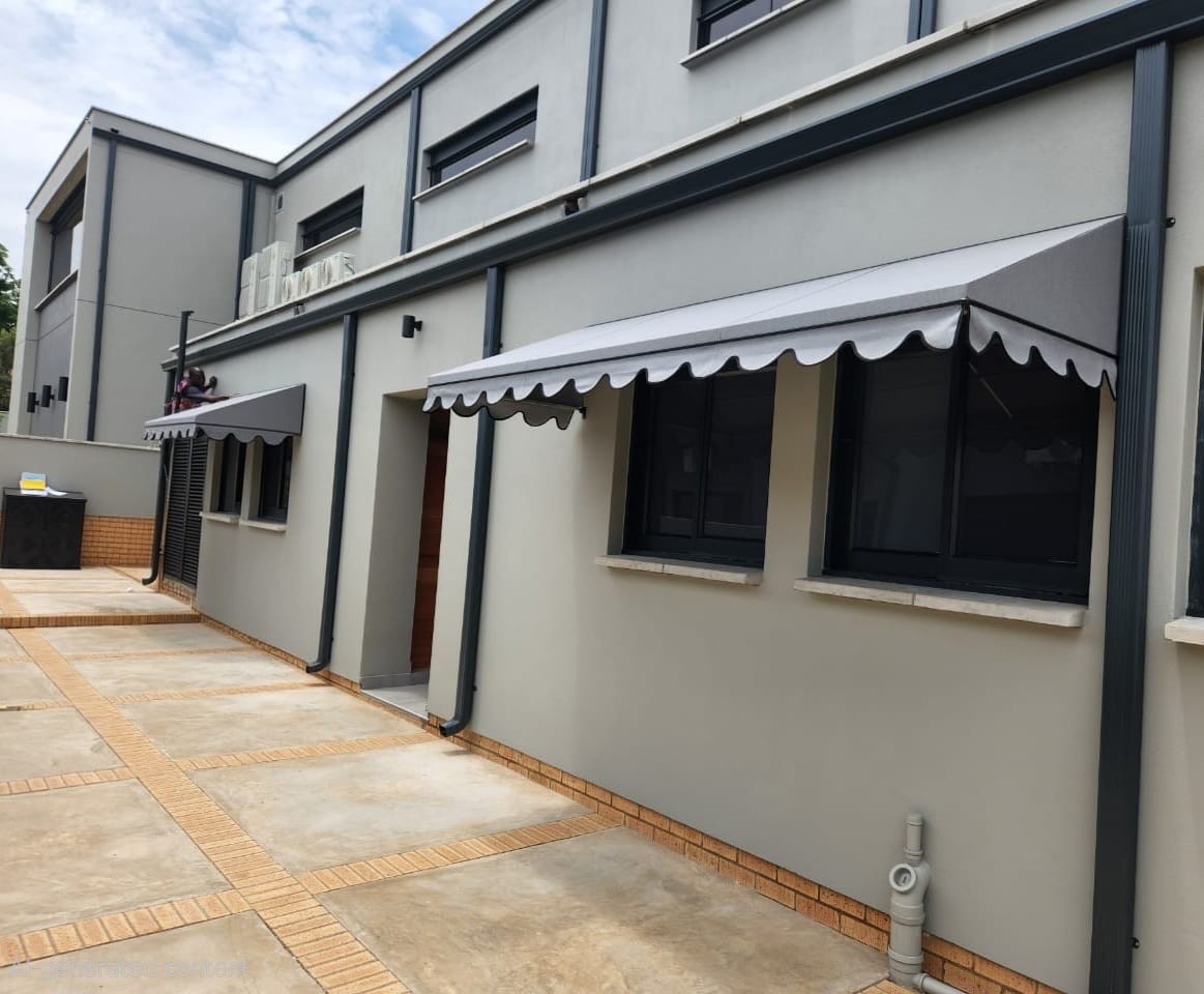 Fixed awnings with scalloped valances along a building