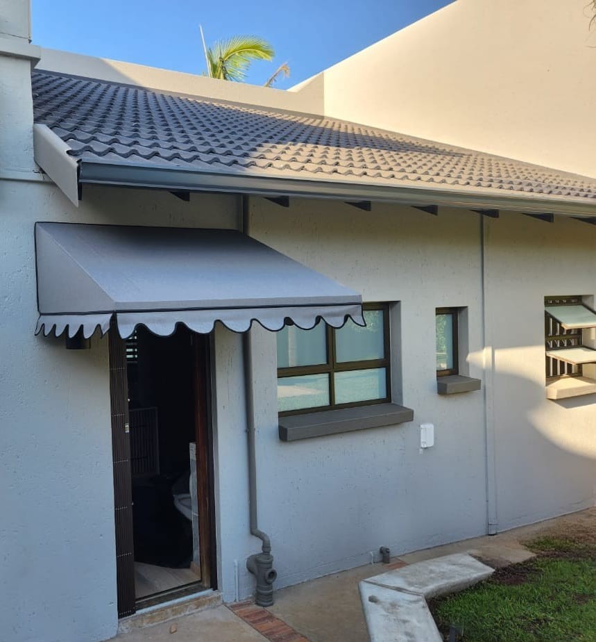 Fixed awning with a scalloped valance over a door and window